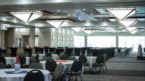 tables and chairs arranged in a spacious room with pyramid shaped chandeliers